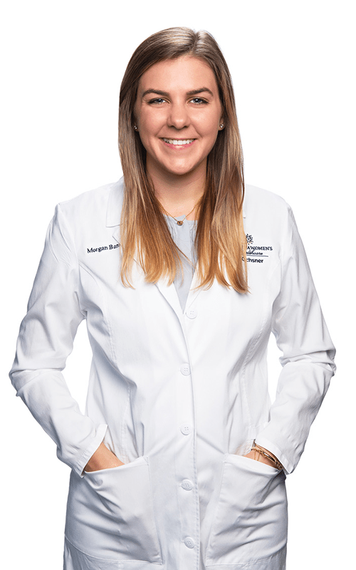 Photo of Dr. Morgan Bankston standing and smiling in white lab coat