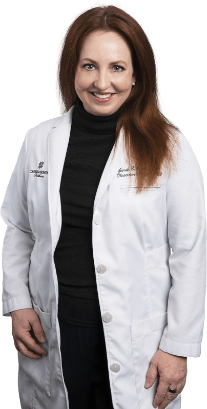 Photo of Dr. Sarah Davis standing and smiling in white lab coat