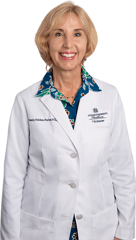 Photo of Dr. Wendy Holden-Parker standing and smiling in white lab coat