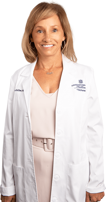 Photo of Dr. Nicolle Hollier standing and smiling in white lab coat
