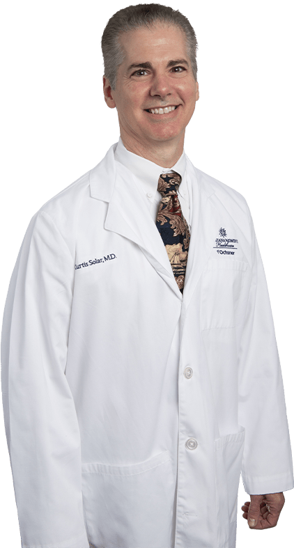 Photo of Dr. Curtis Solar standing and smiling in white lab coat