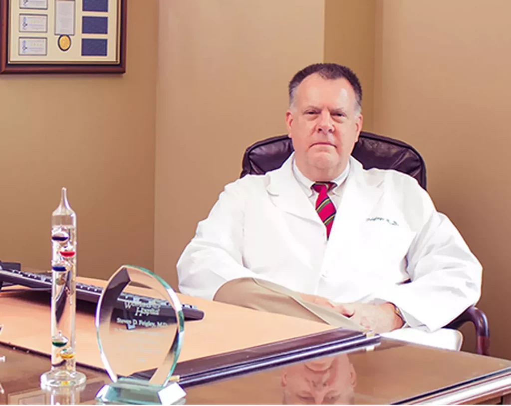 Photo of Dr. Steven Feigley sitting at a desk in his office